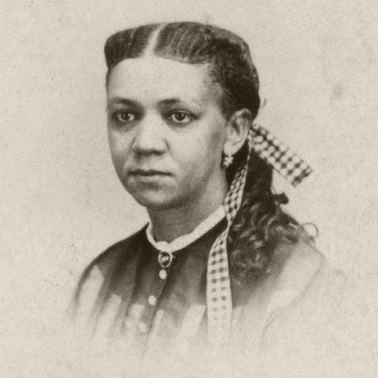 Black and white headshot photo of Fanny Jackson Copin with hair braided with gigham ribbon while also wearing a button up blouse