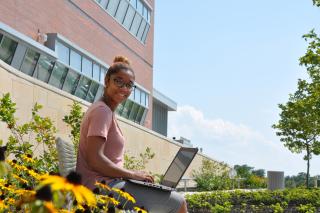 student in front of building